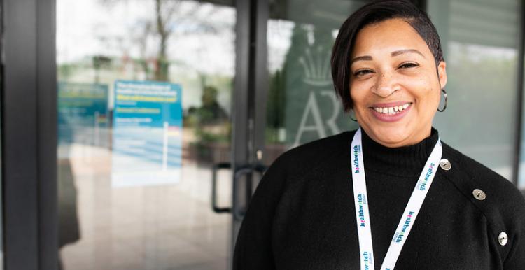 Woman smiling with a healthwatch lanyard on