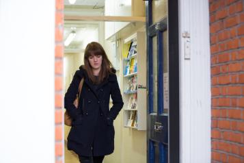 Woman alone walking out of the door looking down