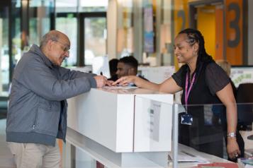 A Healthwatch volunteer speaks with a service user in a hospital reception area