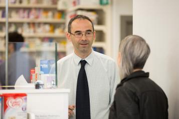 Woman speaking to a male pharmacist