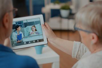 Elder people attending online teleconference on gadget. 