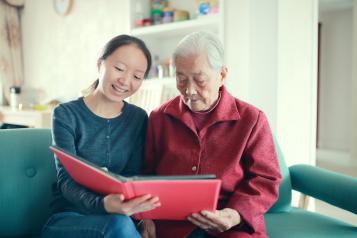 Two women reading together in a care home