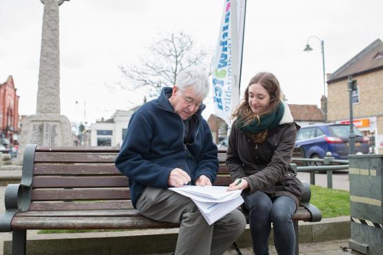 Old man and young woman on a park bench