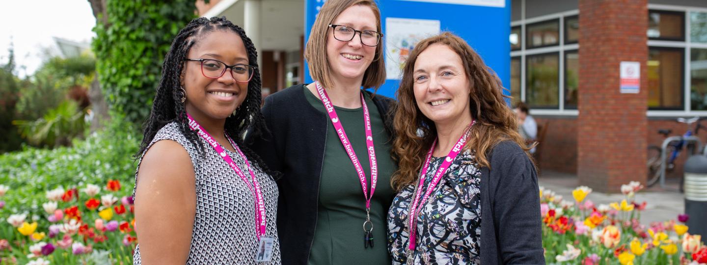 Three Healthwatch staff members standing outside a hospital